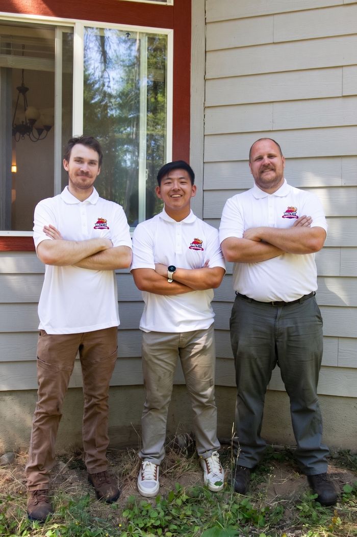 The Muvit Junk Removal crew in branded polos outside a Spokane County home