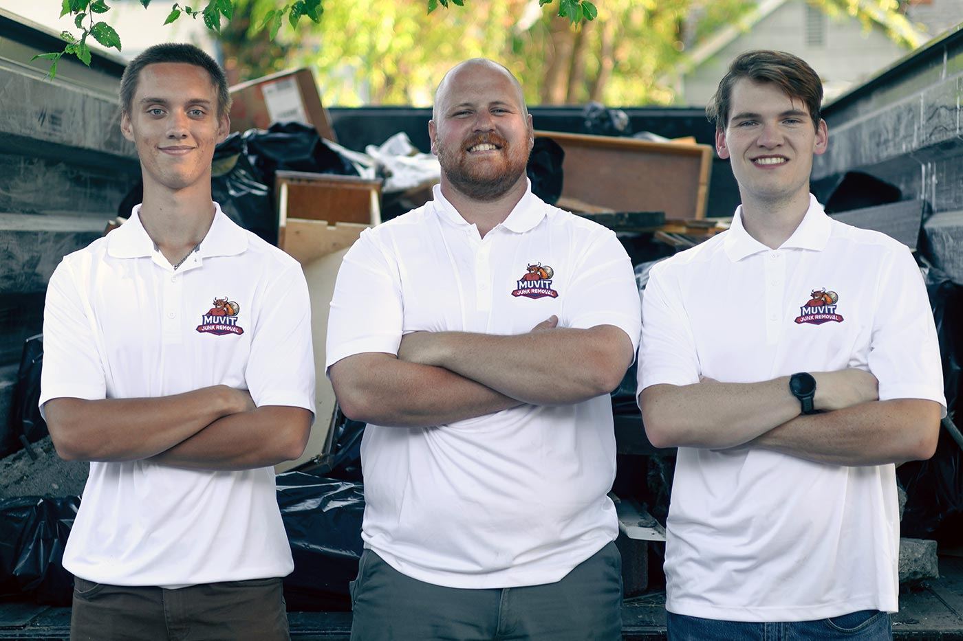 The Muvit Junk Removal crew standing in front of a loaded junk hauling trailer in Spokane, WA